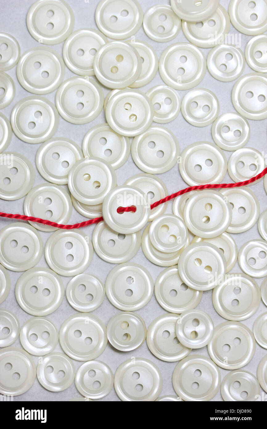 Pearl buttons, red thread Stock Photo - Alamy