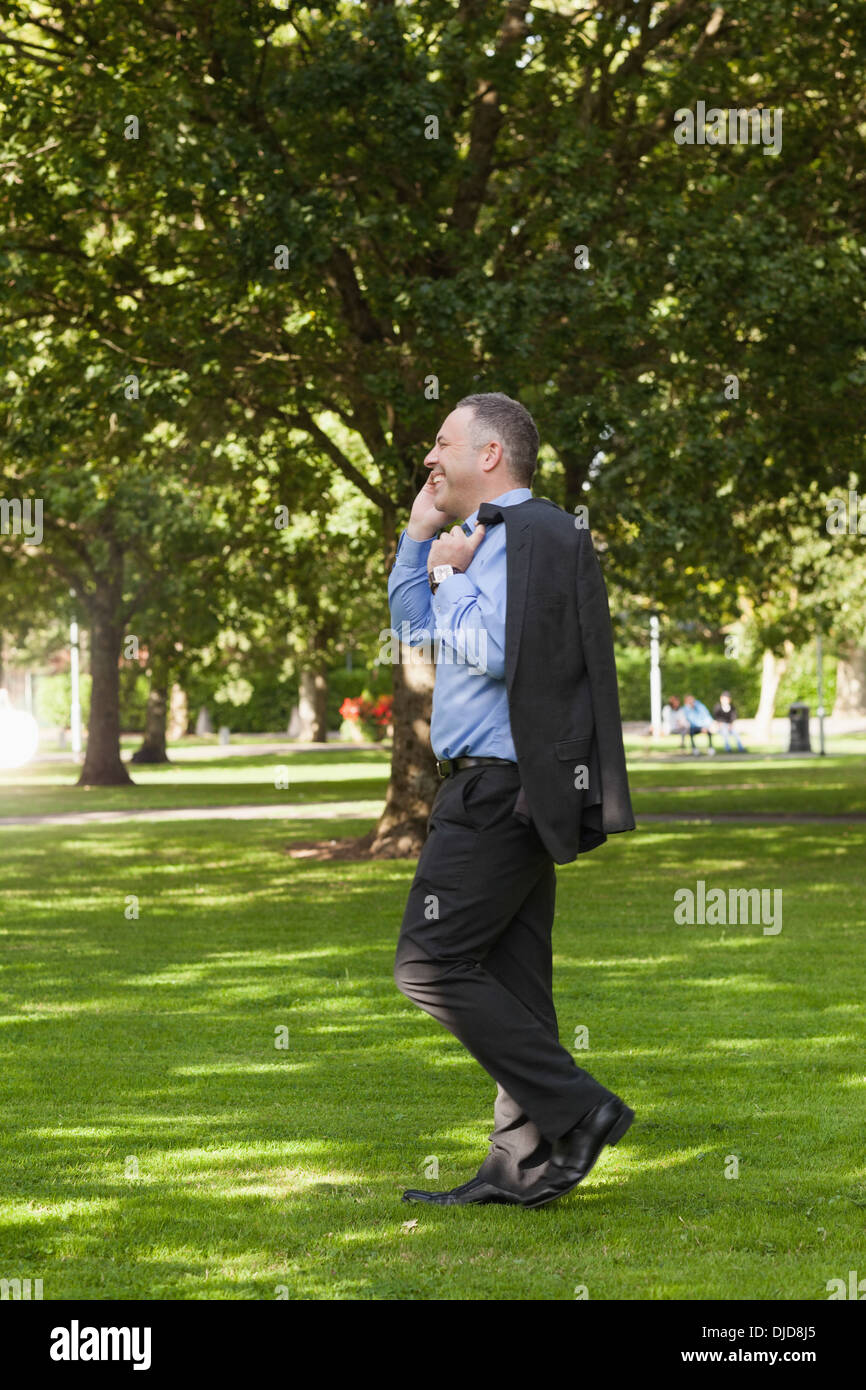 Happy professor walking across campus talking on the phone Stock Photo ...