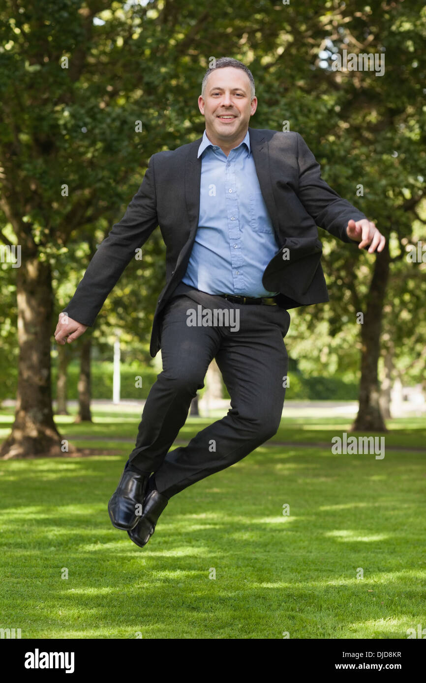 Joyful professor clicking his heels on campus Stock Photo