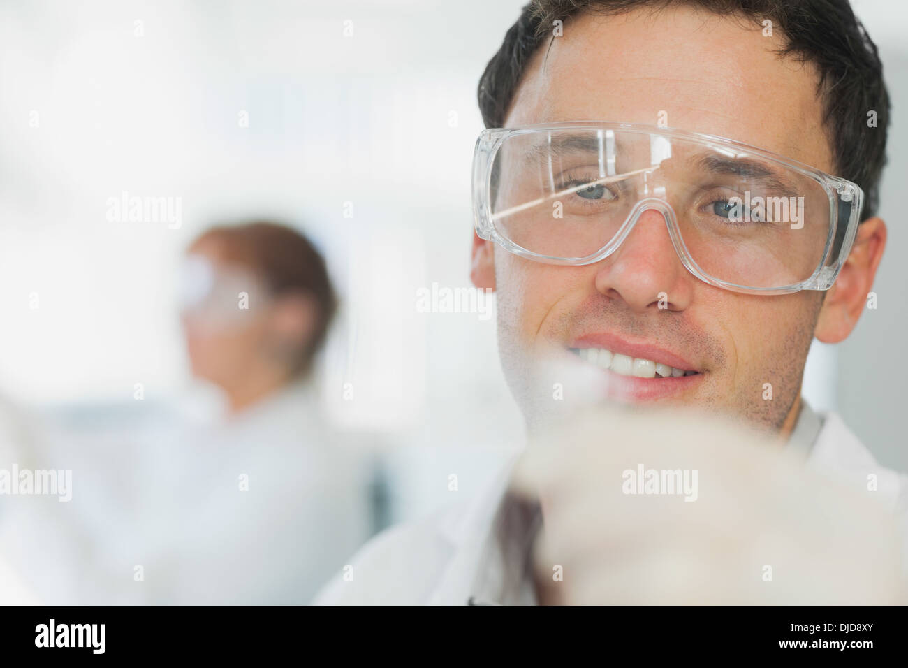 Handsome young scientist looking at microscope slide Stock Photo
