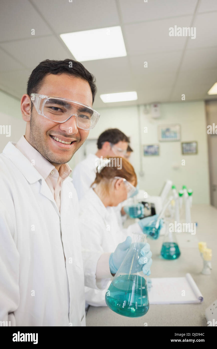 Young male scientist holding an erlenmeyer flask standing in a laboratory Stock Photo