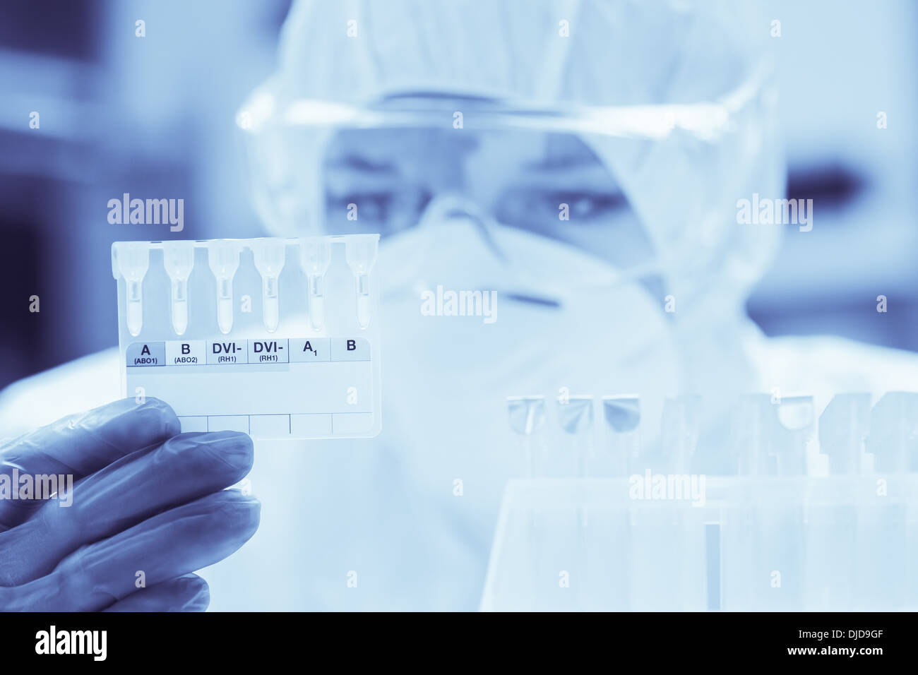 Lab assistant with mask looking closely at test results Stock Photo Alamy