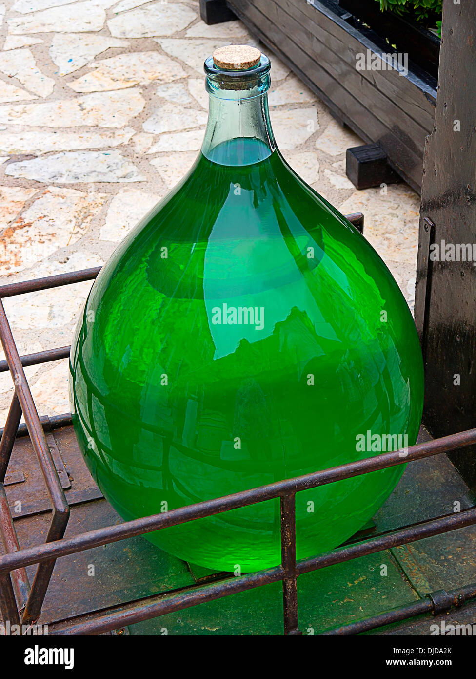 Large Apothecary bottle containing green liquid in the village of Kioni