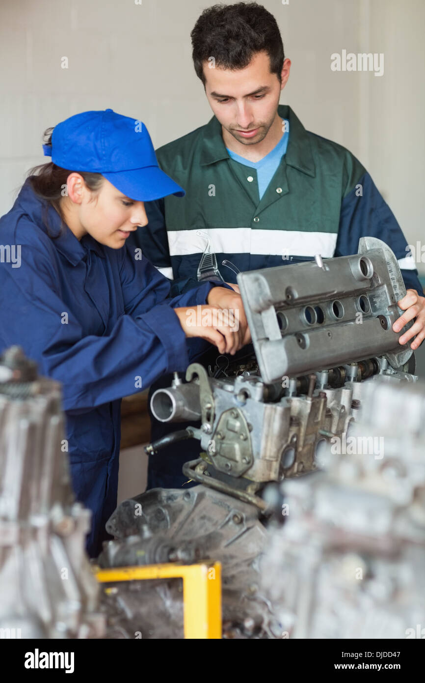 Trainee repairing engine with instructor Stock Photo