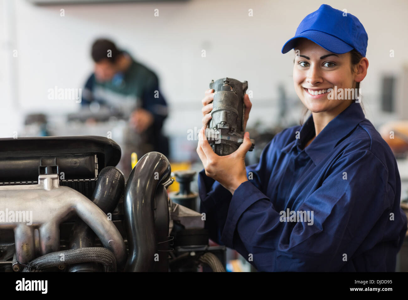 Happy trainee showing part of a machine Stock Photo