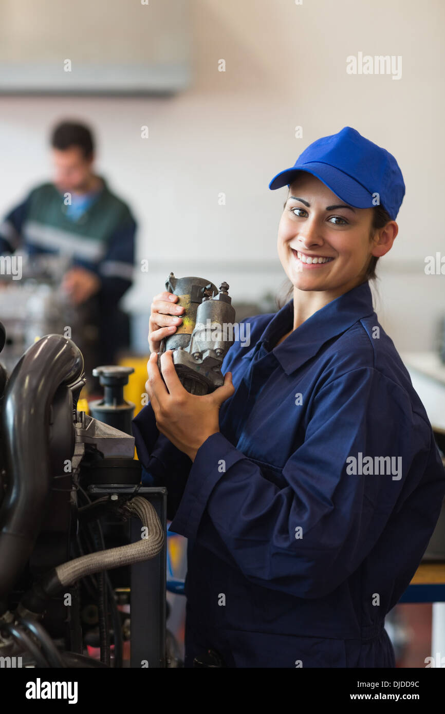 Cheerful trainee showing part of a machine Stock Photo