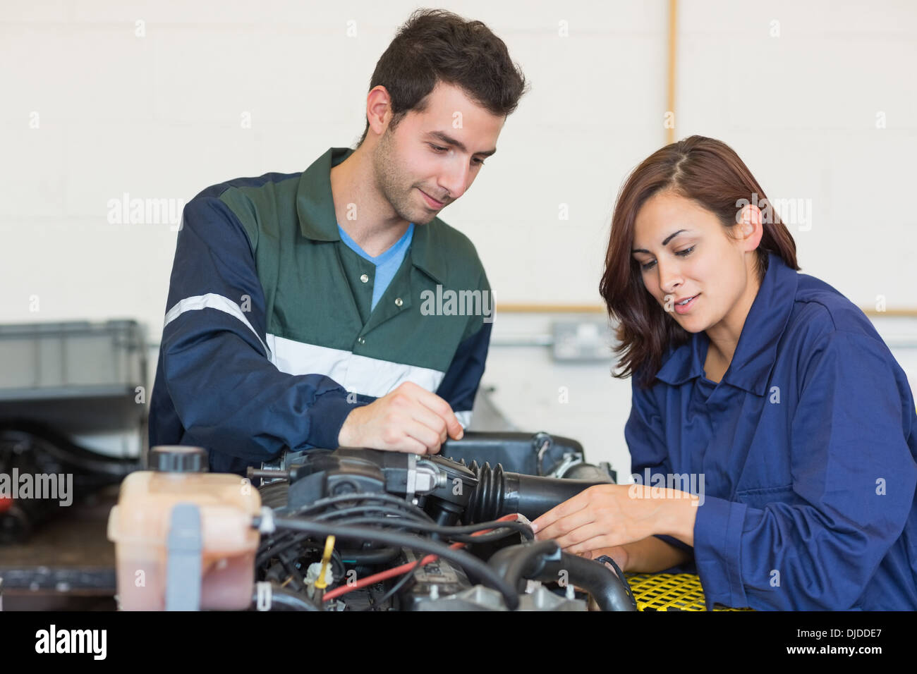 Content instructor and trainee checking a machine Stock Photo