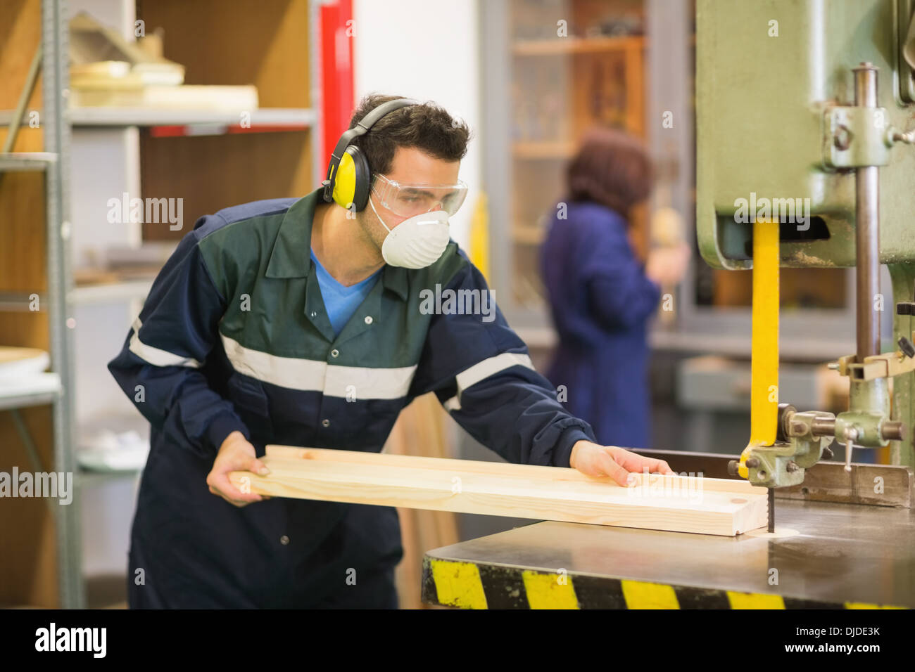 Craftsman wearing safety protection using saw Stock Photo