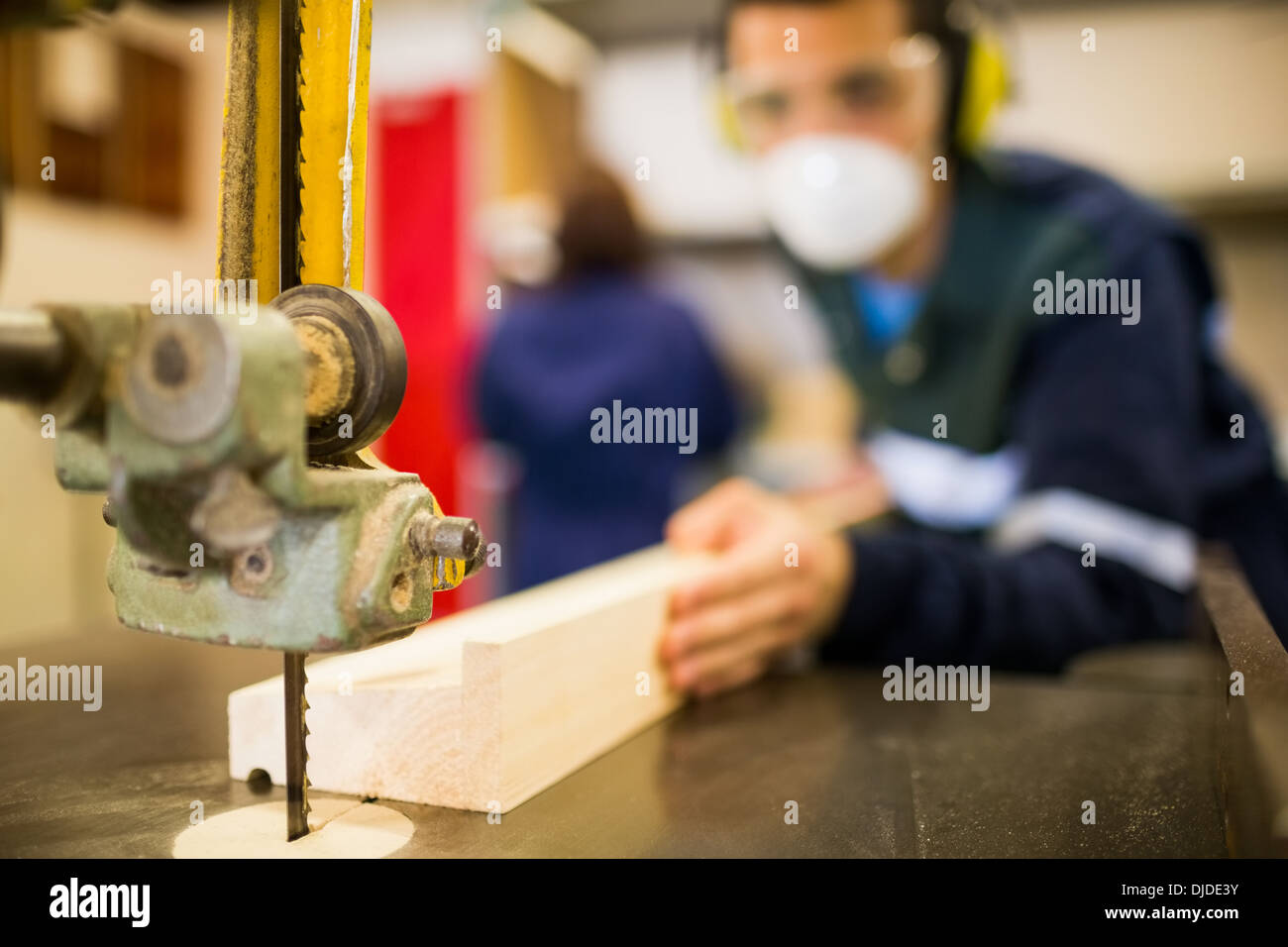 Carpenter wearing safety protection using saw Stock Photo