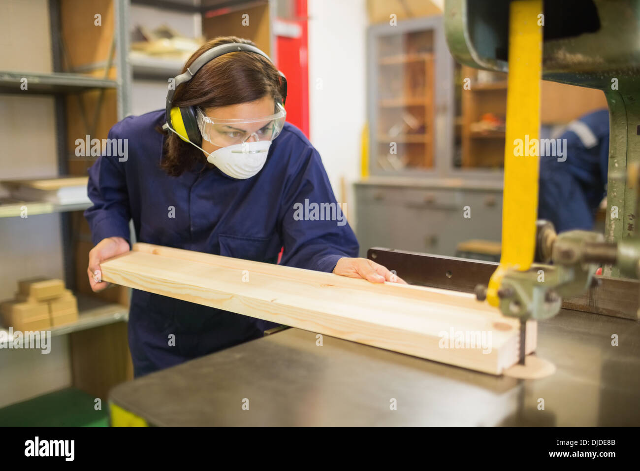 Trainee wearing safety protection using saw Stock Photo