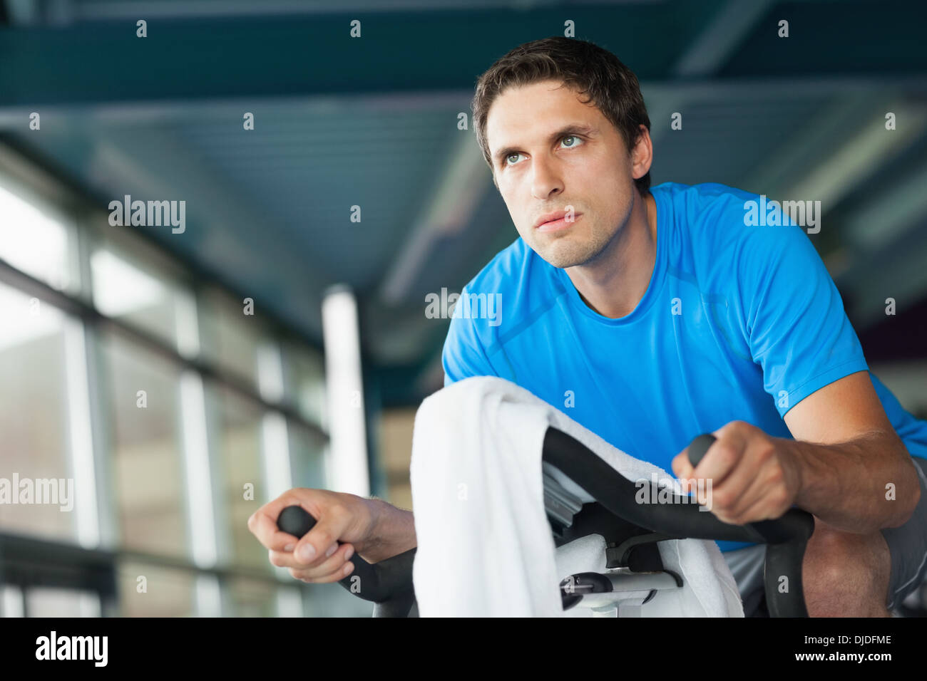 Determined young man working out at spinning class Stock Photo