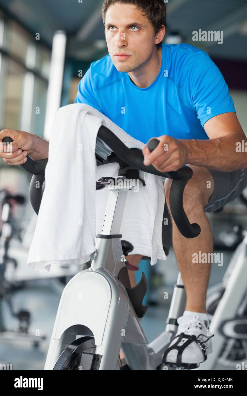 Determined man working out at spinning class Stock Photo