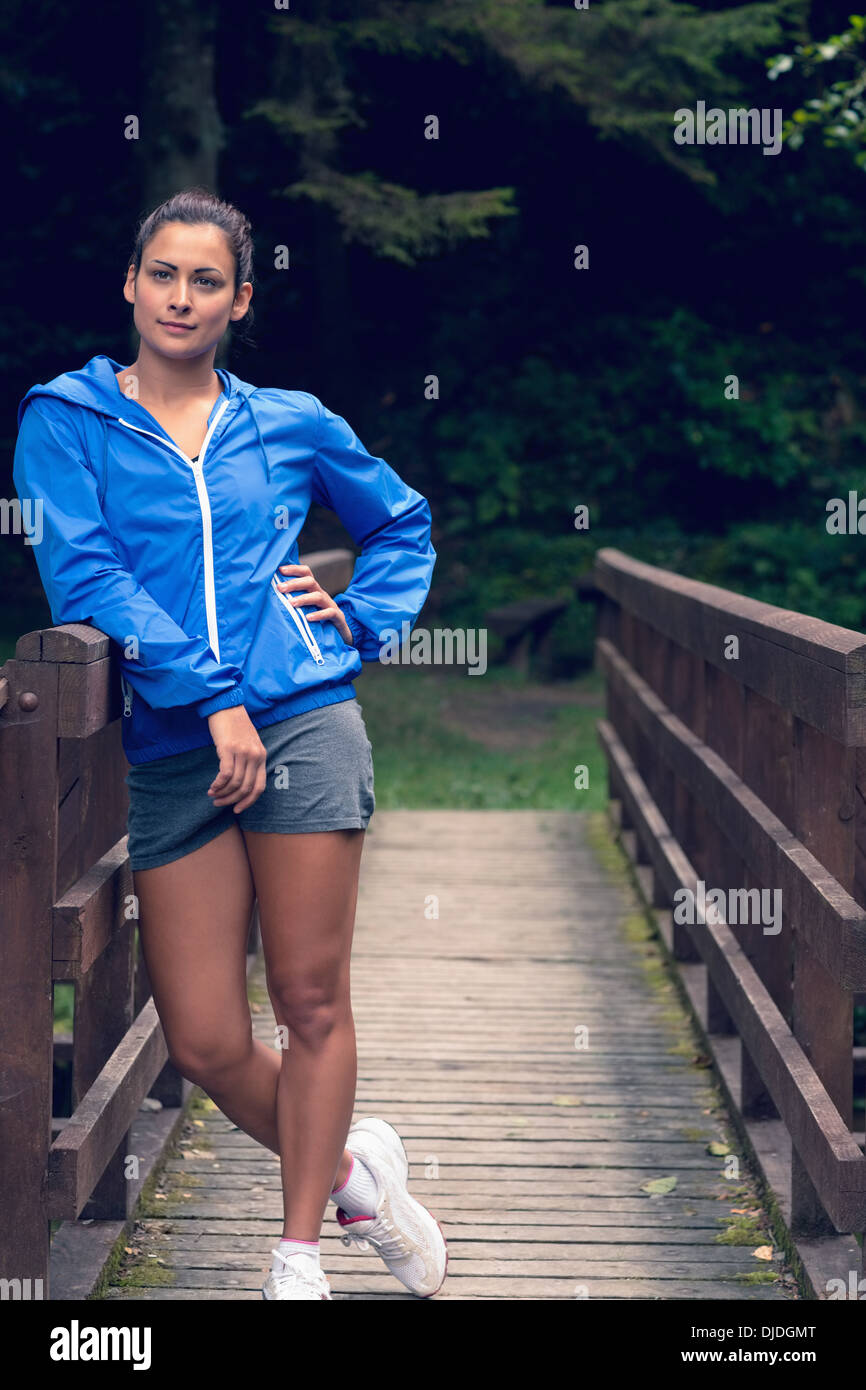 Healthy woman standing on footbridge during exercise Stock Photo