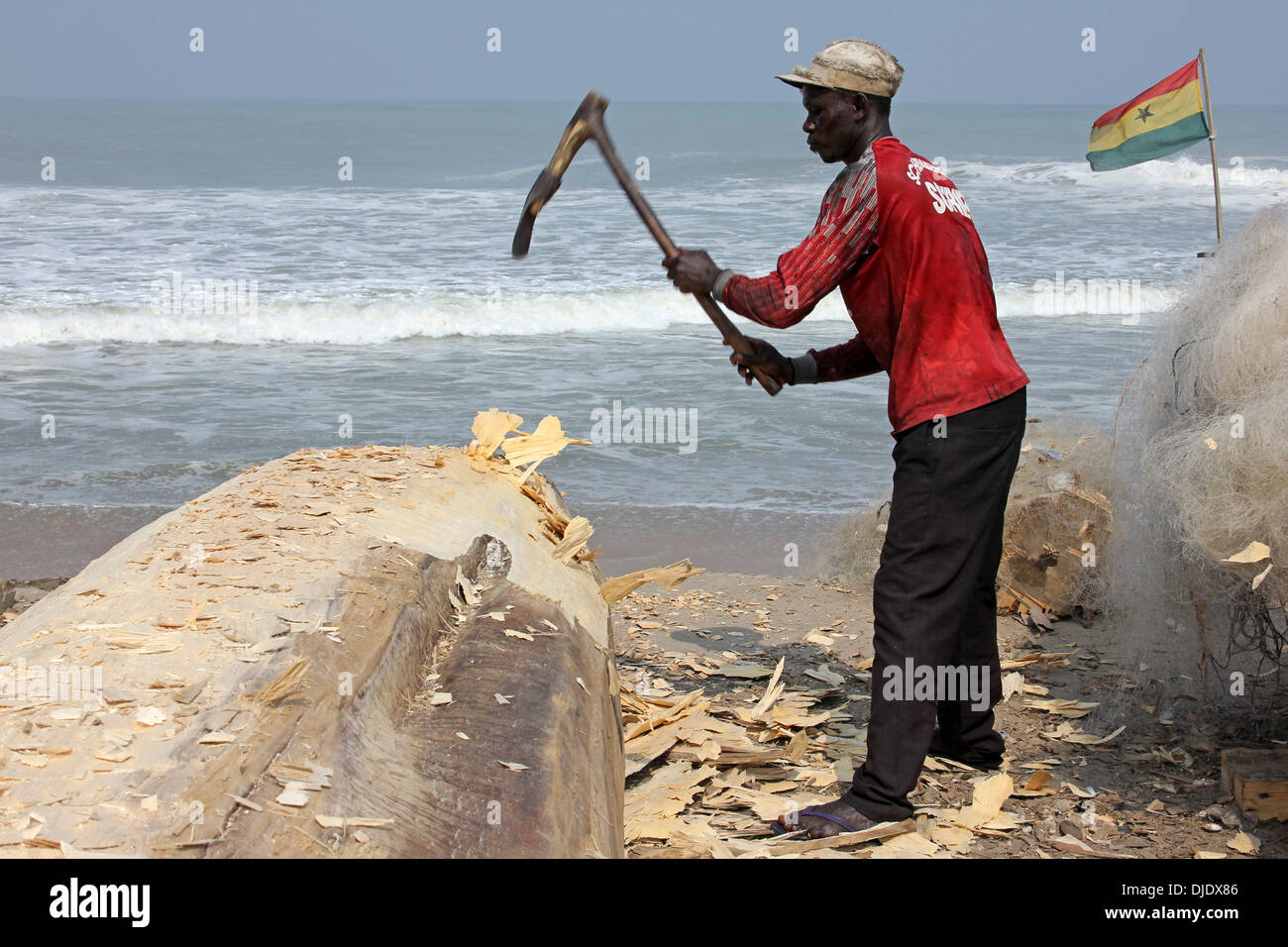 Carpenter Shaping Hull Of Fishing Boat, Ghana Stock Photo