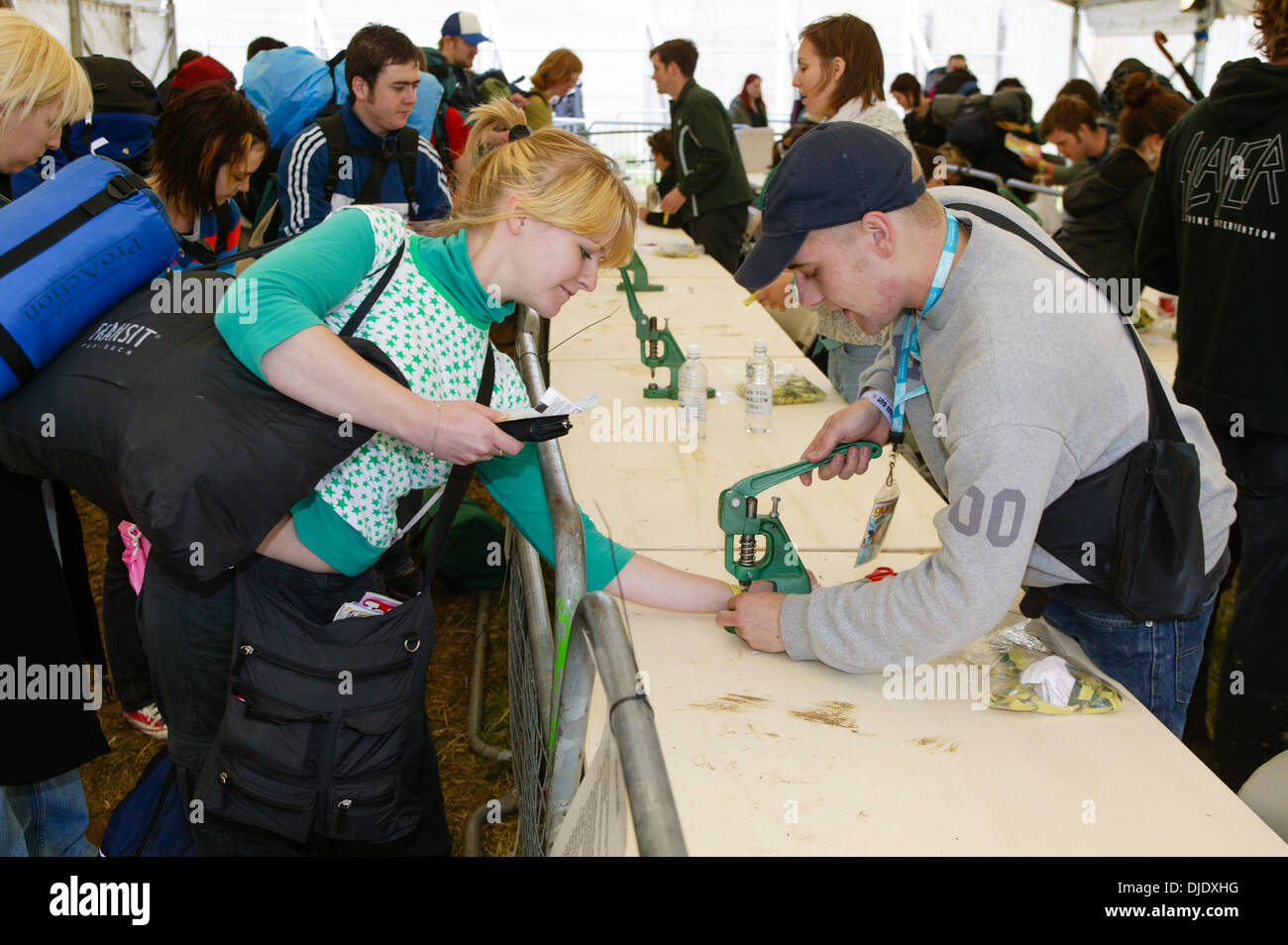 Festival ticket holders having wristbands fitted at the arriving at the Glastonbury Festival