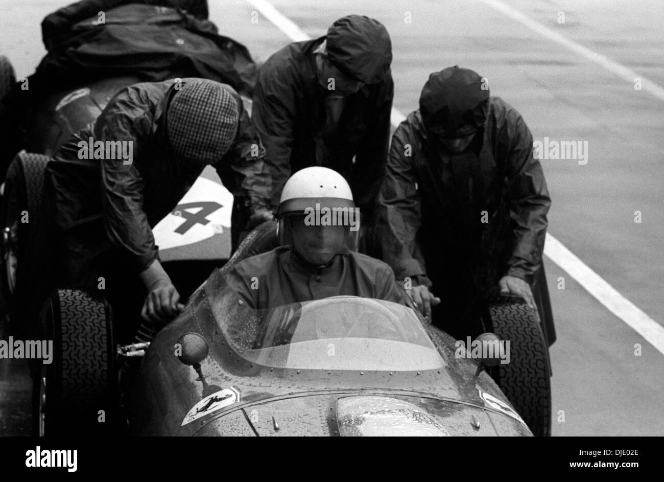 Phil Hill's Ferrari is push-started out of the pits XII BRDC International Trophy race Silverstone England 14 May 1960. Stock Photo