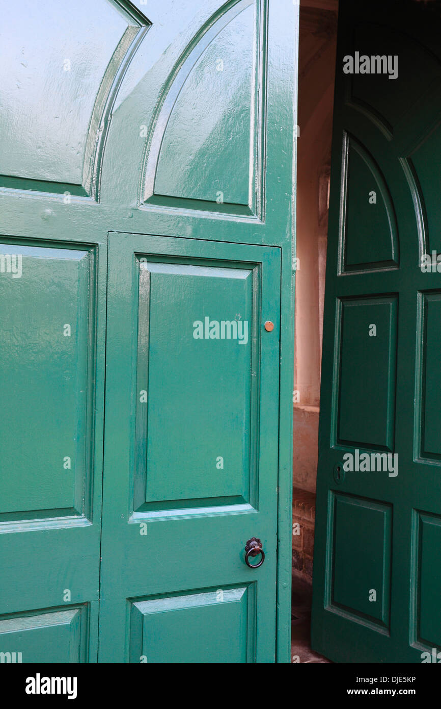 Green door ajar. Entrance to Wymondham Abbey. Stock Photo