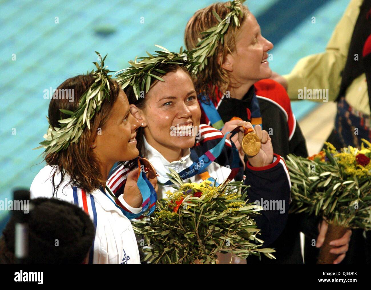 KRT SPORTS STORY SLUGGED: OLY-SWIMMING KRT PHOTO BY KARL MONDON/CONTRA COSTA TIMES (August 16) ATHENS, GREECE  -- Gold medalist Natalie Coughlin, center, celebrates with silver medalist Kirsty Coventry of Zimbabwe, right, and bronze medalist Laure Manaudou of France after the 100-meter backstroke on Monday, August 16, 2004, during the 2004 Olympic Games in Athens, Greece. (gsb) 200 Stock Photo