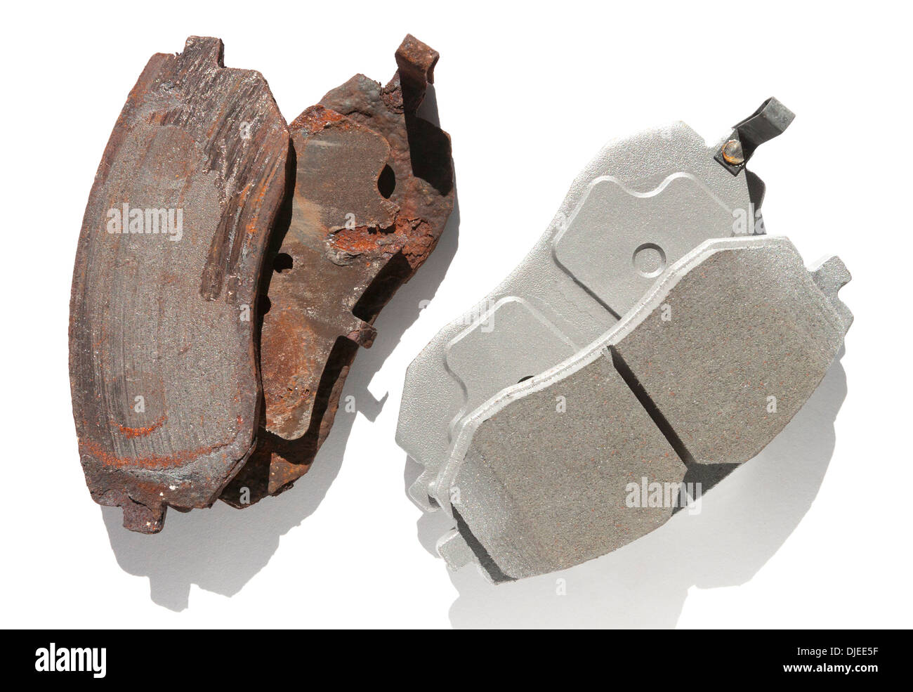 Old and new brake pads compared side by side and silhouetted. Stock Photo