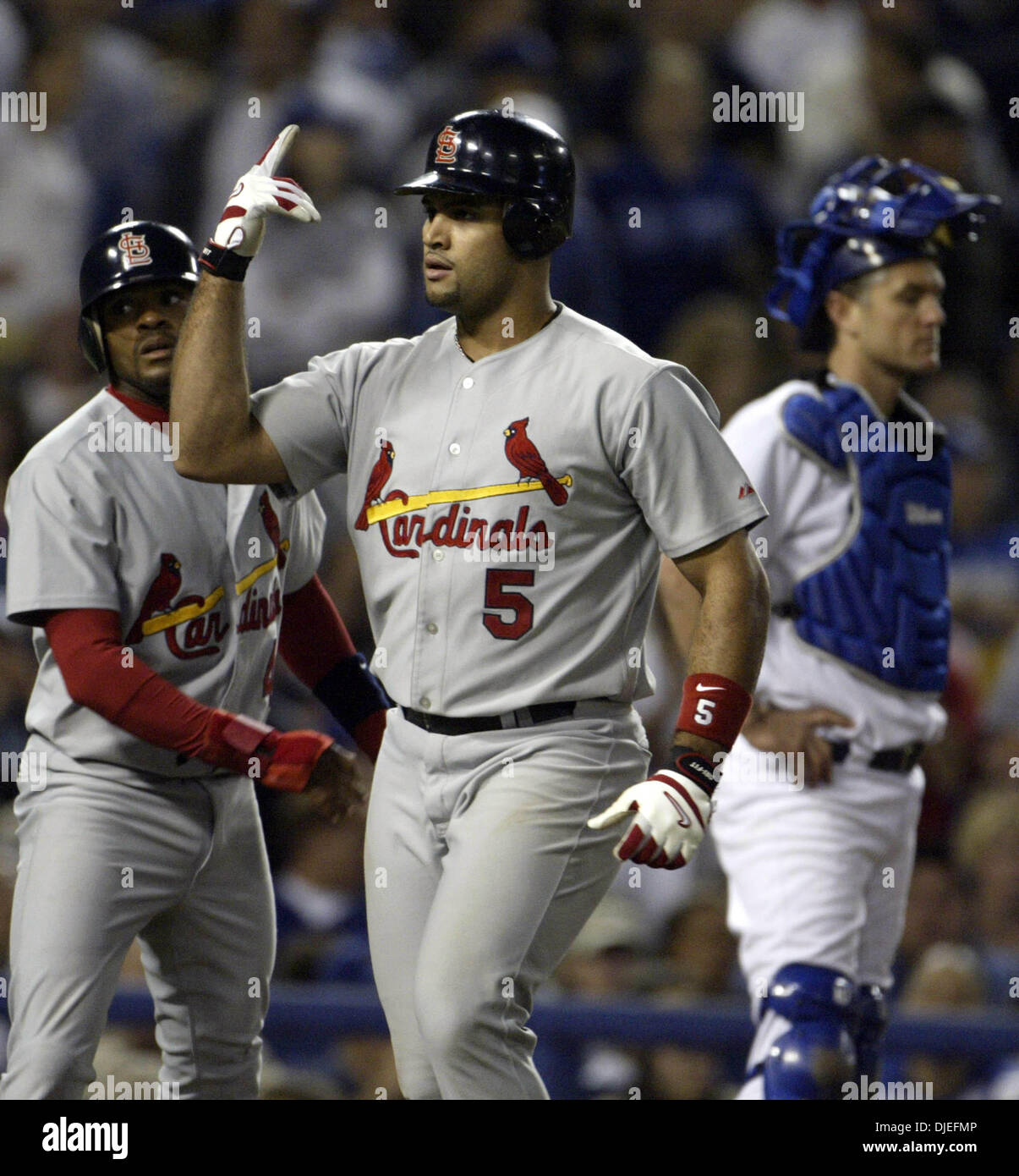 St. Louis Cardinals' Albert Pujols (5) is welcomed home by teammates Scott  Rolen (27) and Larry Walker (33) after belting a three run homer in the  fourth inning against the Dodgers in