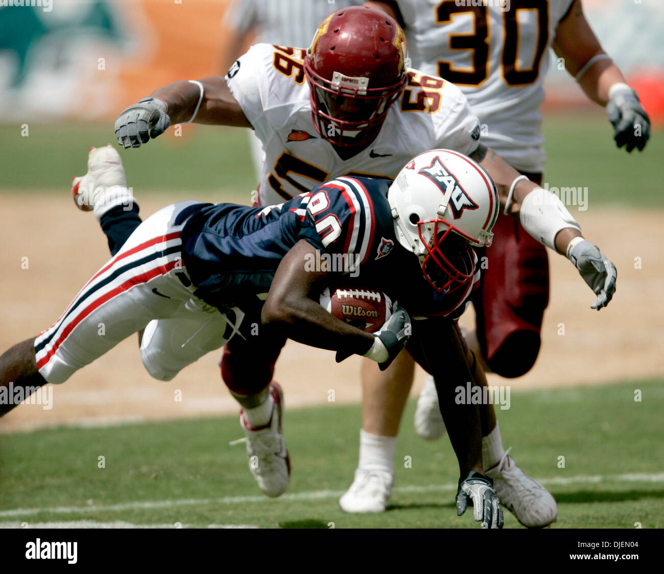 Sep 15, 2007 - West Palm Beach, FL, USA - Floridia Atlantic University wide reciever, LESTER JEAN, stretches to reach for a first down before being tackled by Wisconsin's STEVE DAVIS. (Credit Image: © Carl Kiilsgaard/Palm Beach Post/ZUMA Press) RESTRICTIONS: USA Tabloid RIGHTS OUT! Stock Photo