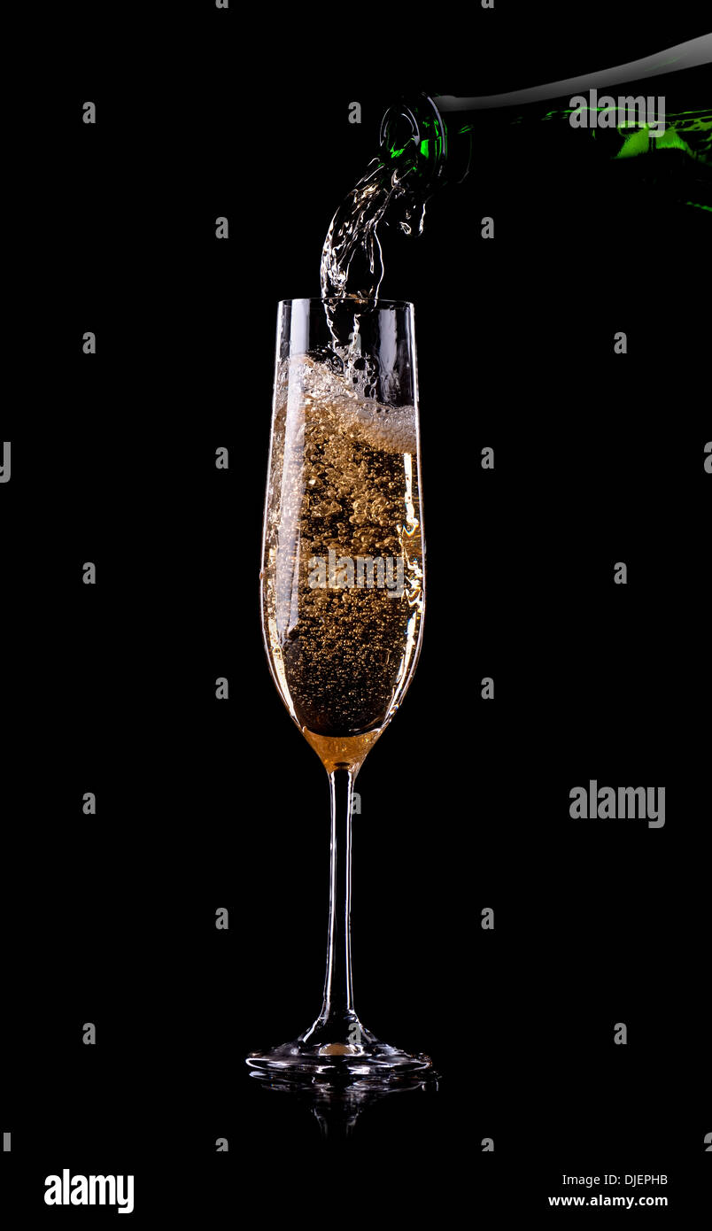 Golden champagne pouring in glass from a bottle Stock Photo