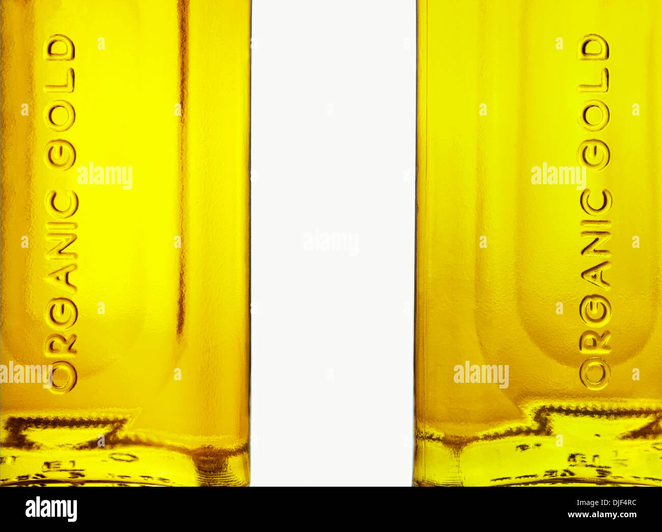 Two olive oil bottles with the text 'organic gold' on white background. Stock Photo
