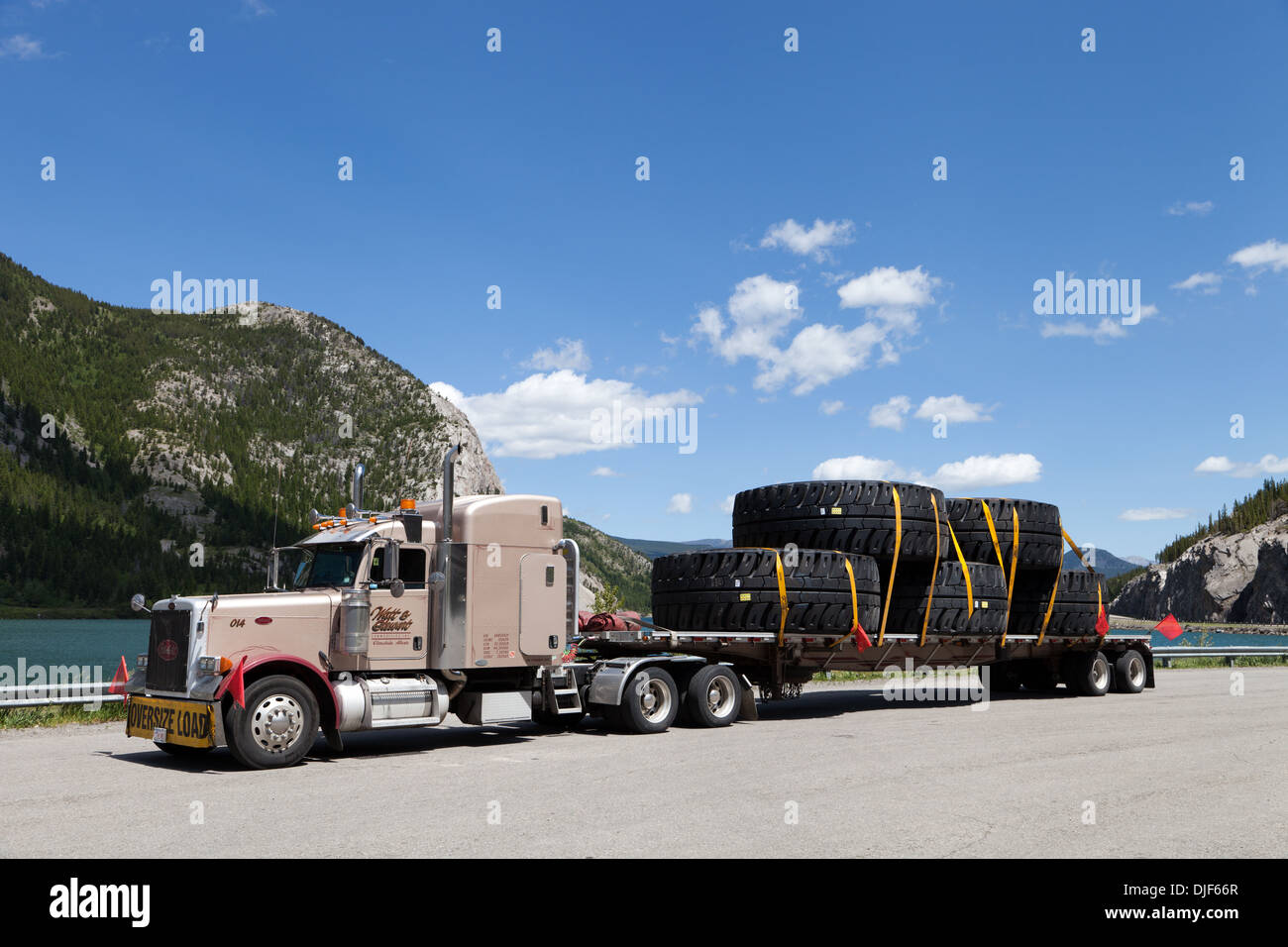 Truck hauling large tires parked at Crowsnest Lake in pull out Alberta, Canada Stock Photo