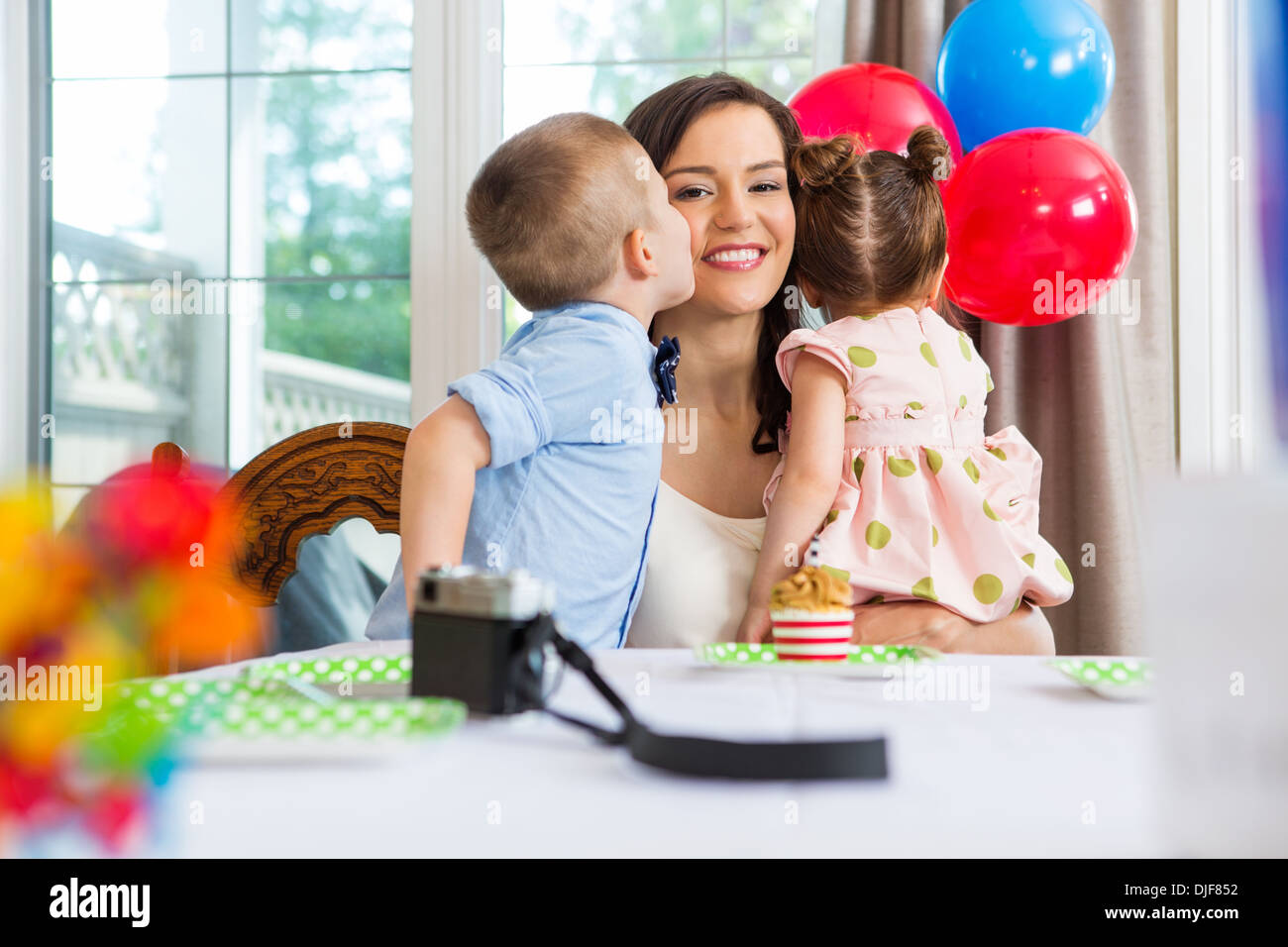 Birthday Boy Kissing Mother At Home Stock Photo