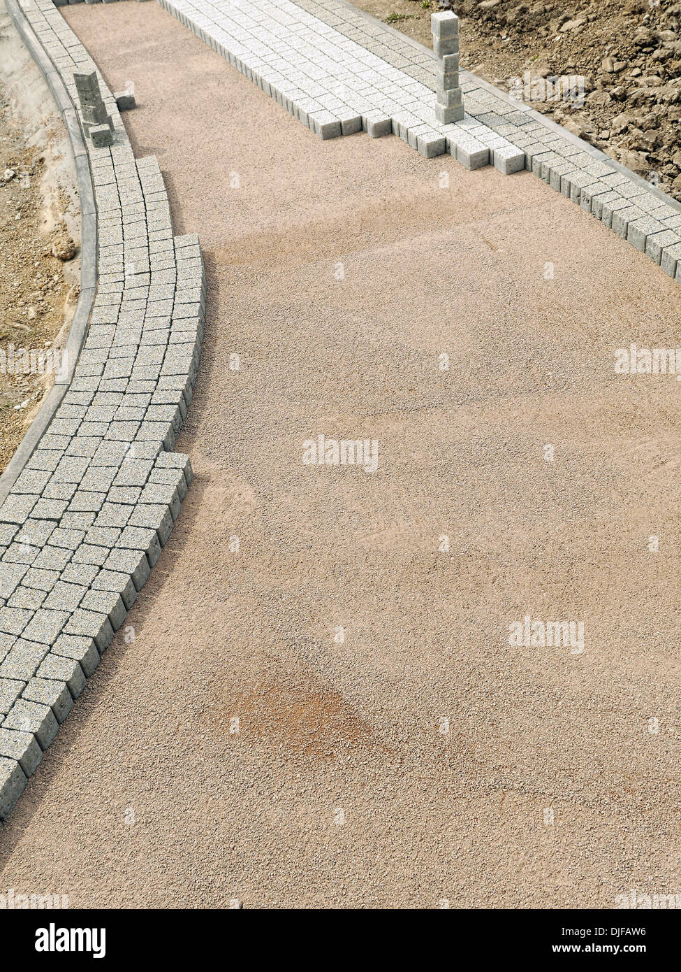 Unfinished pavement path being laid from concrete pavement blocks with mineral topping Stock Photo