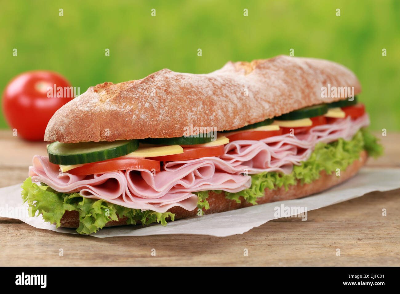Baguette with ham, cheese, tomatoes, cucumber and lettuce Stock Photo