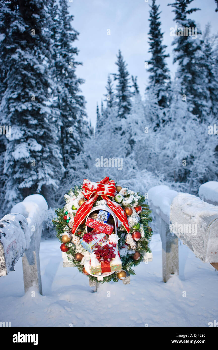 Several Mailboxes Lined Up In A Row With One Decorated With A Christmas Wreath During Winter In Alaska Stock Photo