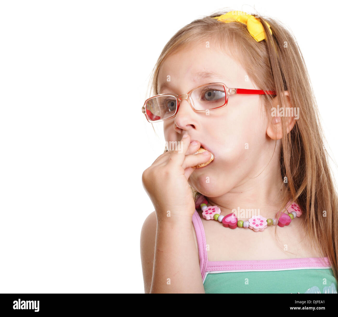 Funny little girl in glasses eating a bread doing fun isolated on white
