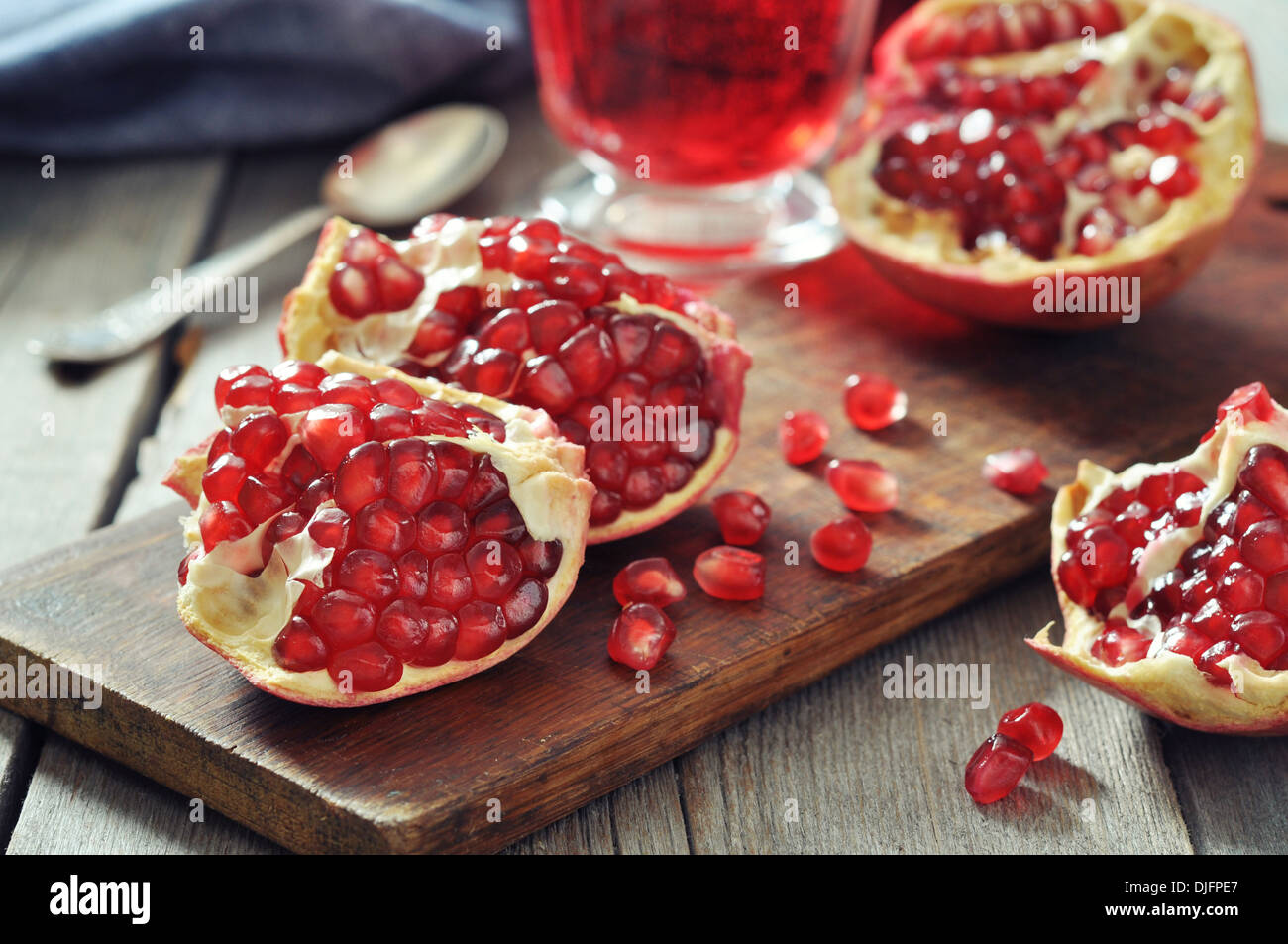 Ripe pomegranate fruit and glass of juice on wooden background Stock Photo