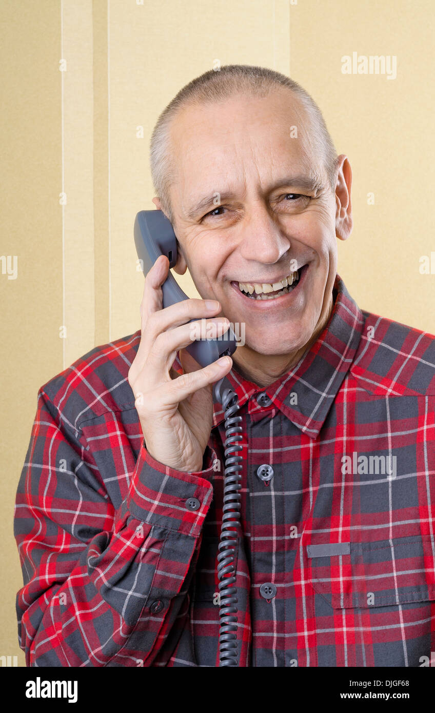 Happy man laughing and speaking with a friend on phone Stock Photo