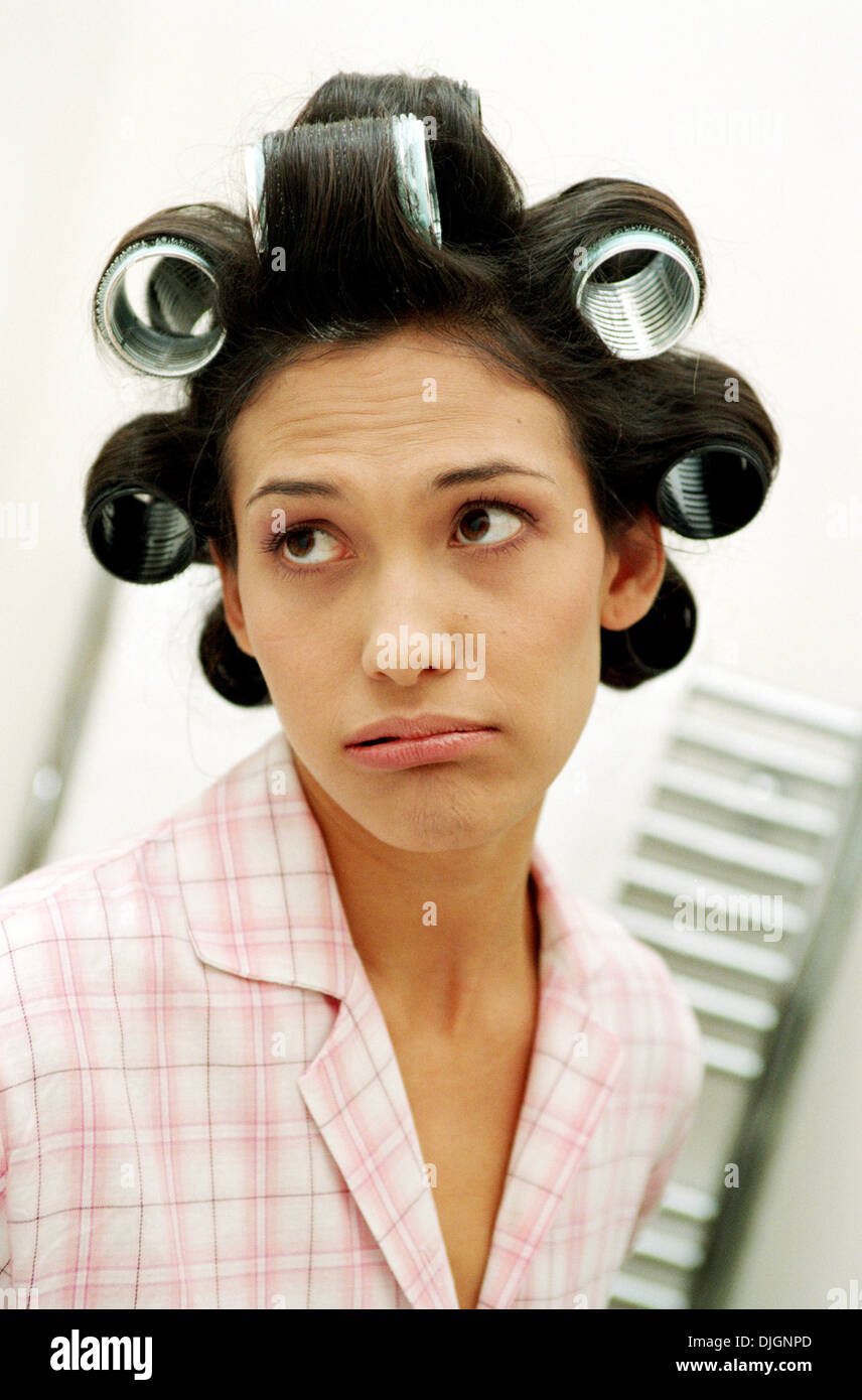 Woman in pajamas, hair in rollers Stock Photo
