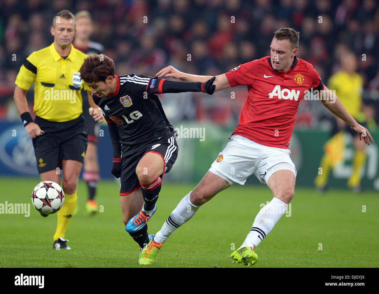 Leverkusen, Germany. 27th Nov, 2013. Leverkusen's Heung-Min Son (L) and Manchester's Phil Jones vie for the ball during the Champions League soccer match between Bayer 04 Leverkusen and Manchester United in the BayArena in Leverkusen, Germany, 27 November 2013. Photo: Frederico Gambarini/dpa/Alamy Live News Stock Photo