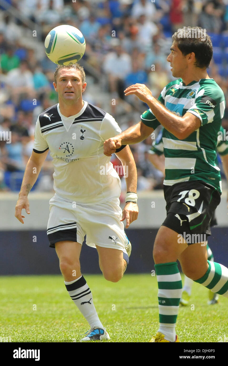 Tottenham Hotspur Fc Striker Robbie Keane 10 And Sporting Lisbon Defender Leandro Grimi 18 Fight For Possesio As English Premier League Club Tottenham Hotspur Face Super Liga Club Sporting Club De Portugal