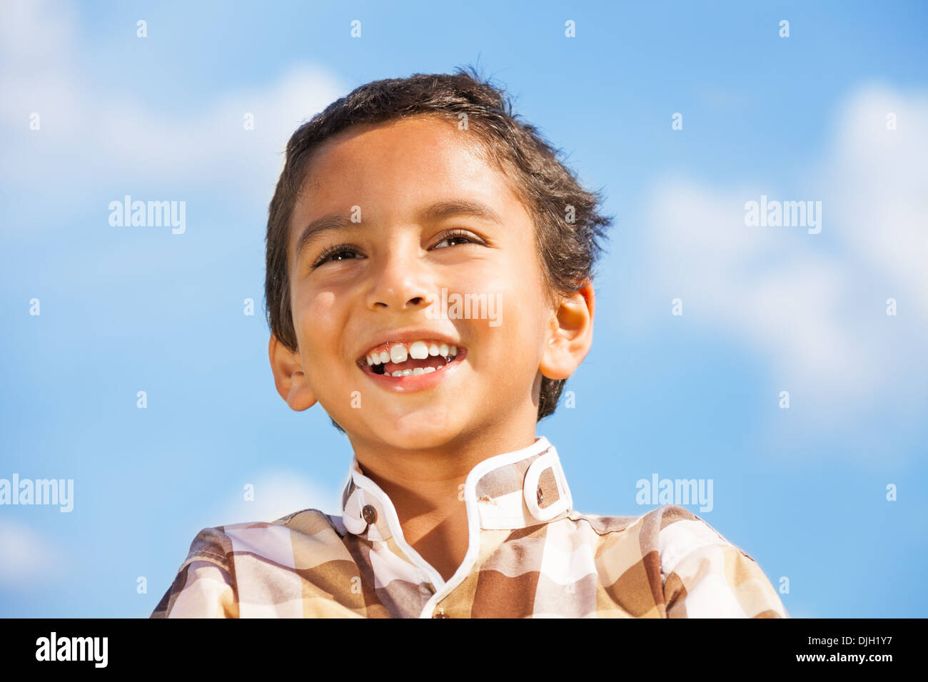 Laughing 6 years old boy portrait over the blue sky  Stock Photo