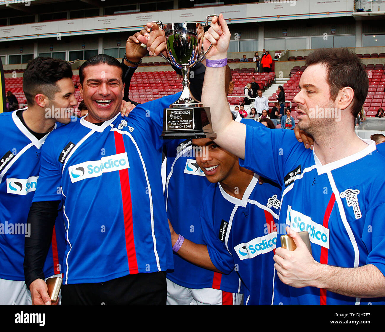 Tamer Hassan and Danny Dyer holding up trophy after winning Celebrity Soccer Six match held at West Ham Football Club grounds Stock Photo