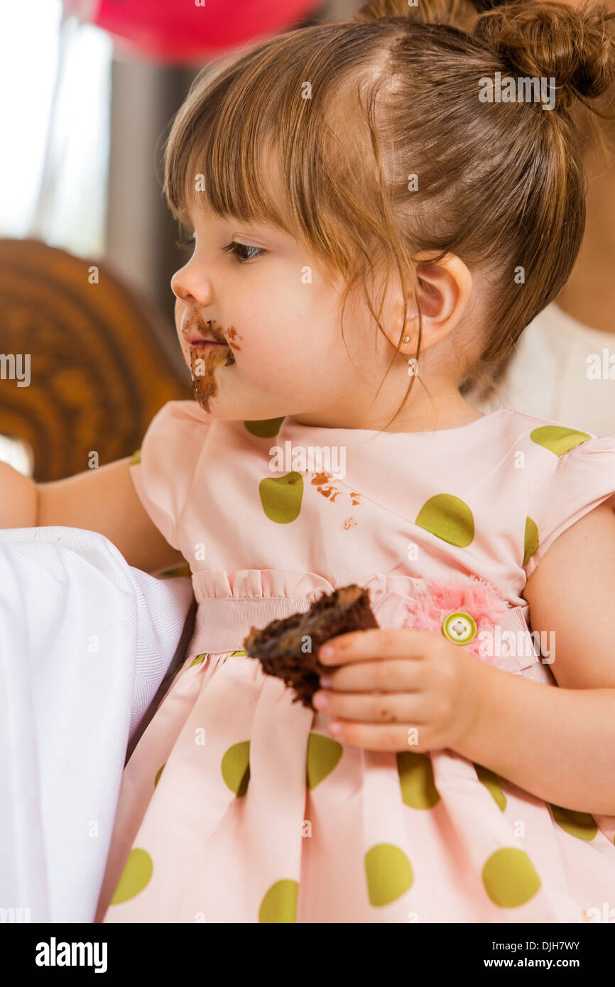 Girl Eating Cake With Icing On Her Face Stock Photo Alamy