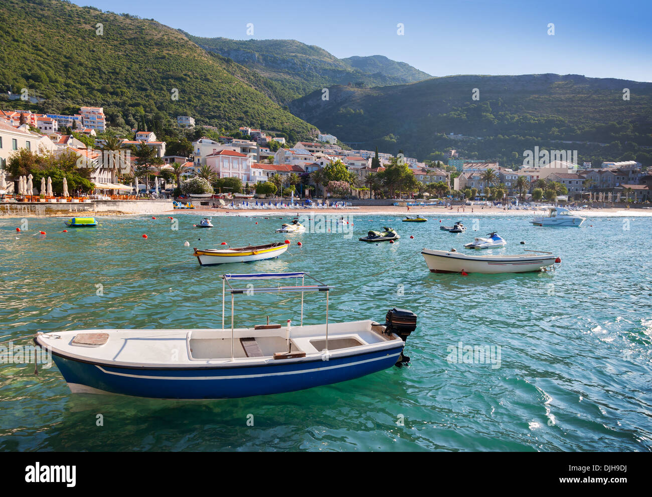Fishing and pleasure boats float moored in Adriatic sea water. Petrovac town, Montenegro Stock Photo
