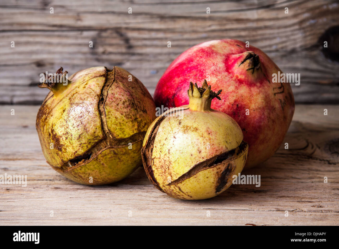 Ripe pomegranates close up on old wood background Stock Photo