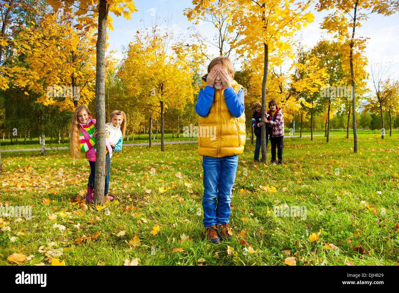 Free Vector  Little kids playing hide and seek in park playing game with  friends outdoor in vacations boy counting boys hiding begind tree girl  running to hide