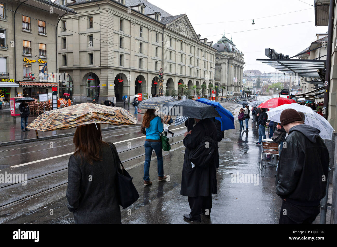 People with Umbrellas in a City street on a wet day,  Kornhausplatz, Bern Switzerland Stock Photo