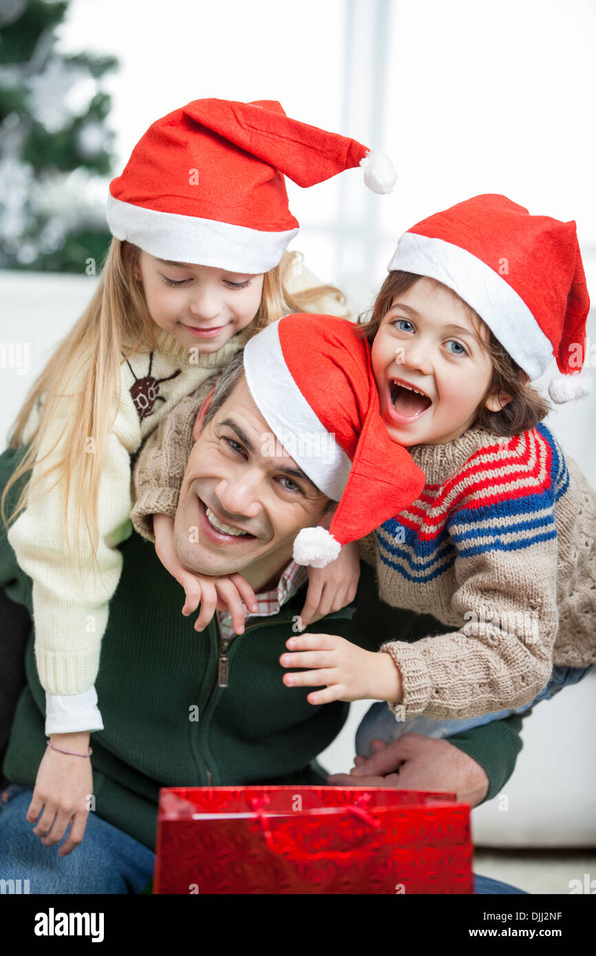 Father Piggybacking Children During Christmas Stock Photo