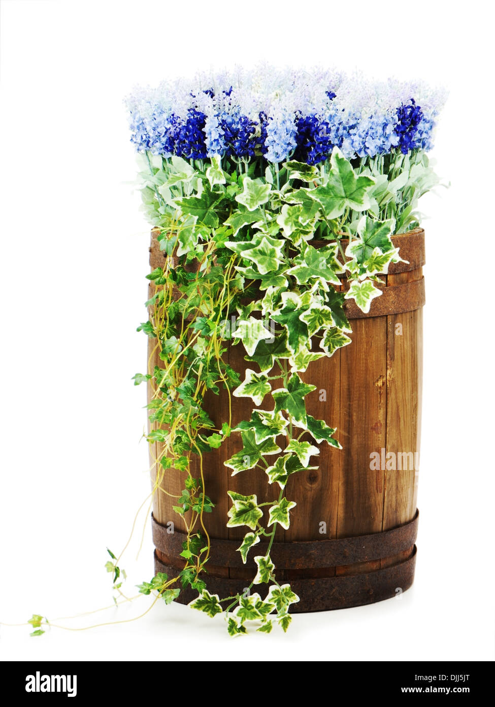 Composition of artificial flowers in old wooden barrel isolated on white background. Closeup. Stock Photo
