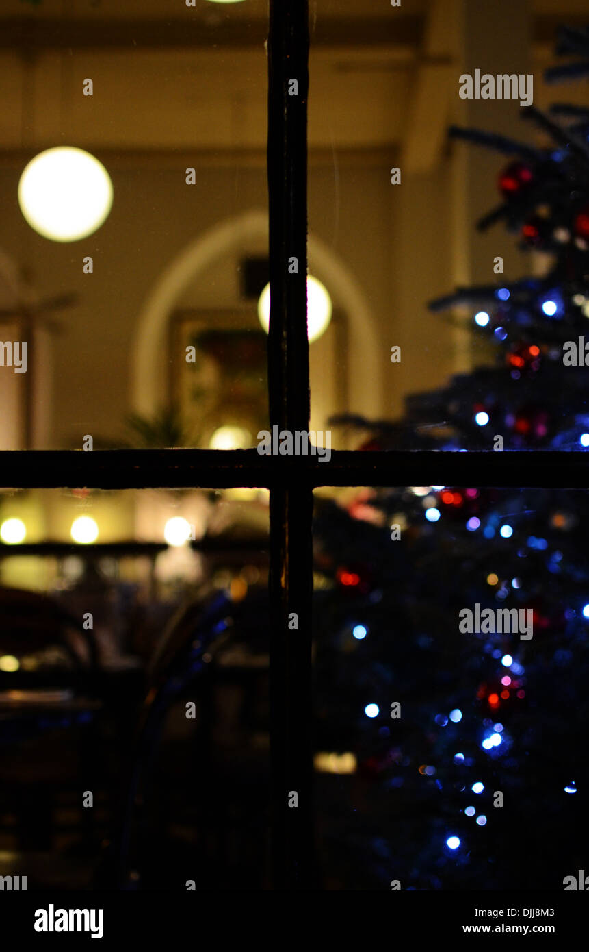 A window at night showing lights and a Christmas tree Stock Photo