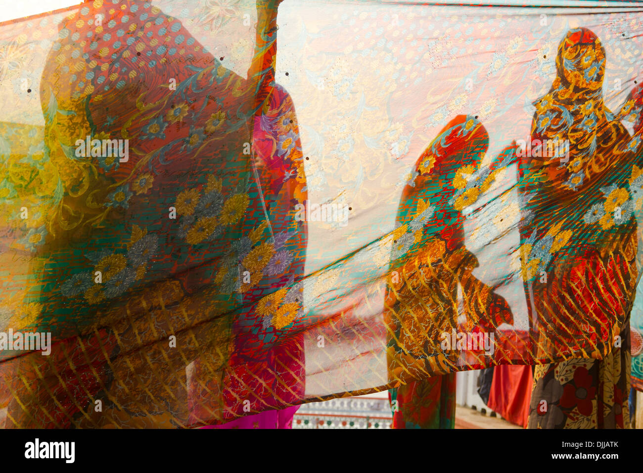 A group of women keep the saris that have been washed in the waters of ...