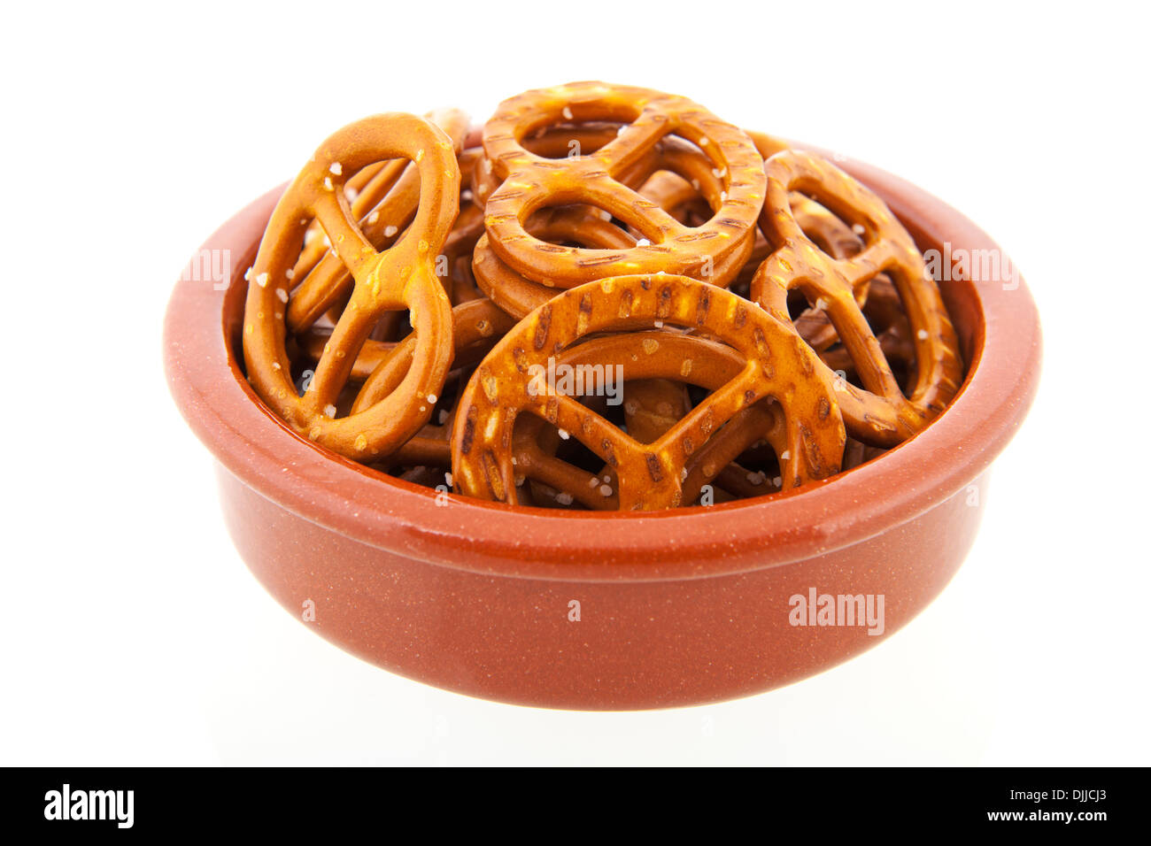 German pretzels in brown bowl isolated over white background Stock Photo